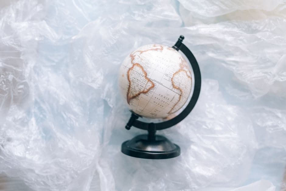 A globe wrapped in plastic symbolizes environmental issues and the need for sustainability.