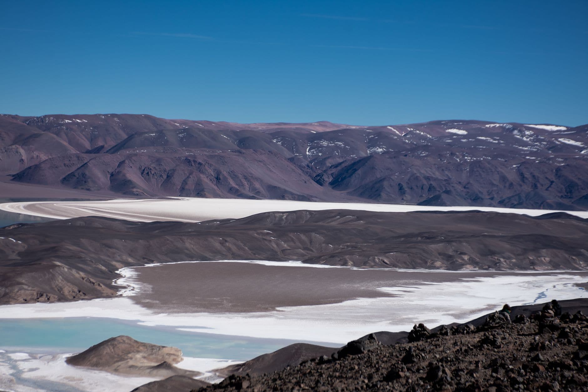 Stunning view of salt flats and mountains under a clear blue sky in Catamarca, Argentina.